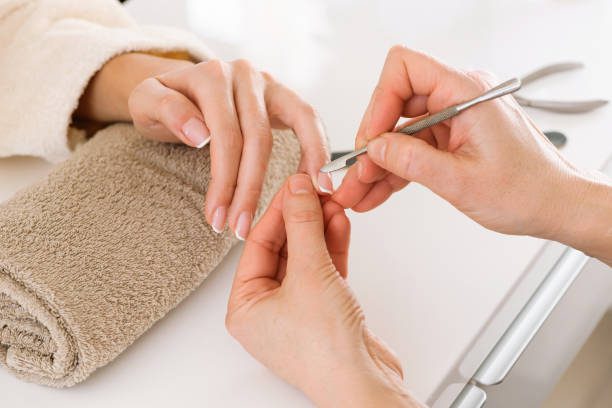 An image of someone getting an acrylic powder manicure.